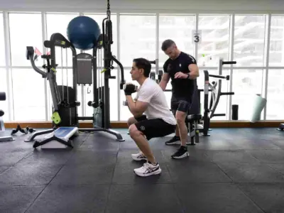 Man+Doing+Front+Squats+in+a+Small+Group+Personal+Training+Gym